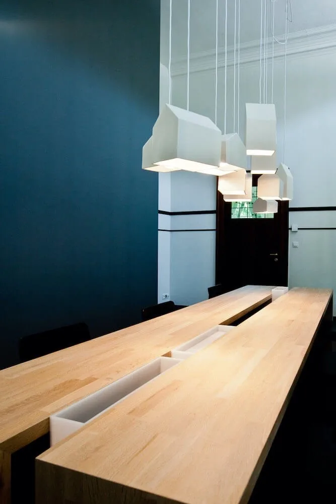 Houten vergadertafel met lampen in het kantoor van Synctiv
